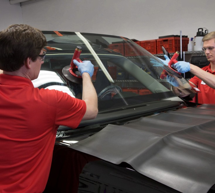 Technicians replacing a windshield