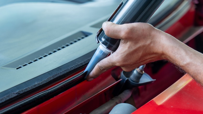 Technician sealing windshield
